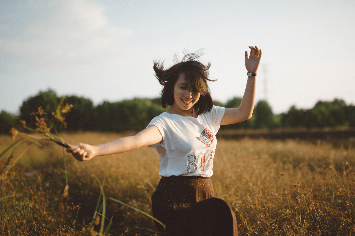 young woman happily holding a flower