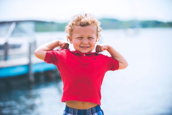 A healthy boy flexing his arms