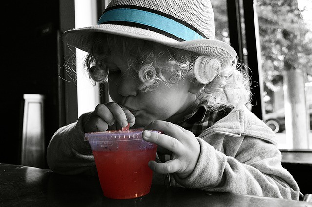 A small girl drinking kombucha