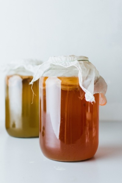 Kombucha tea in glass jars with white cloth cover