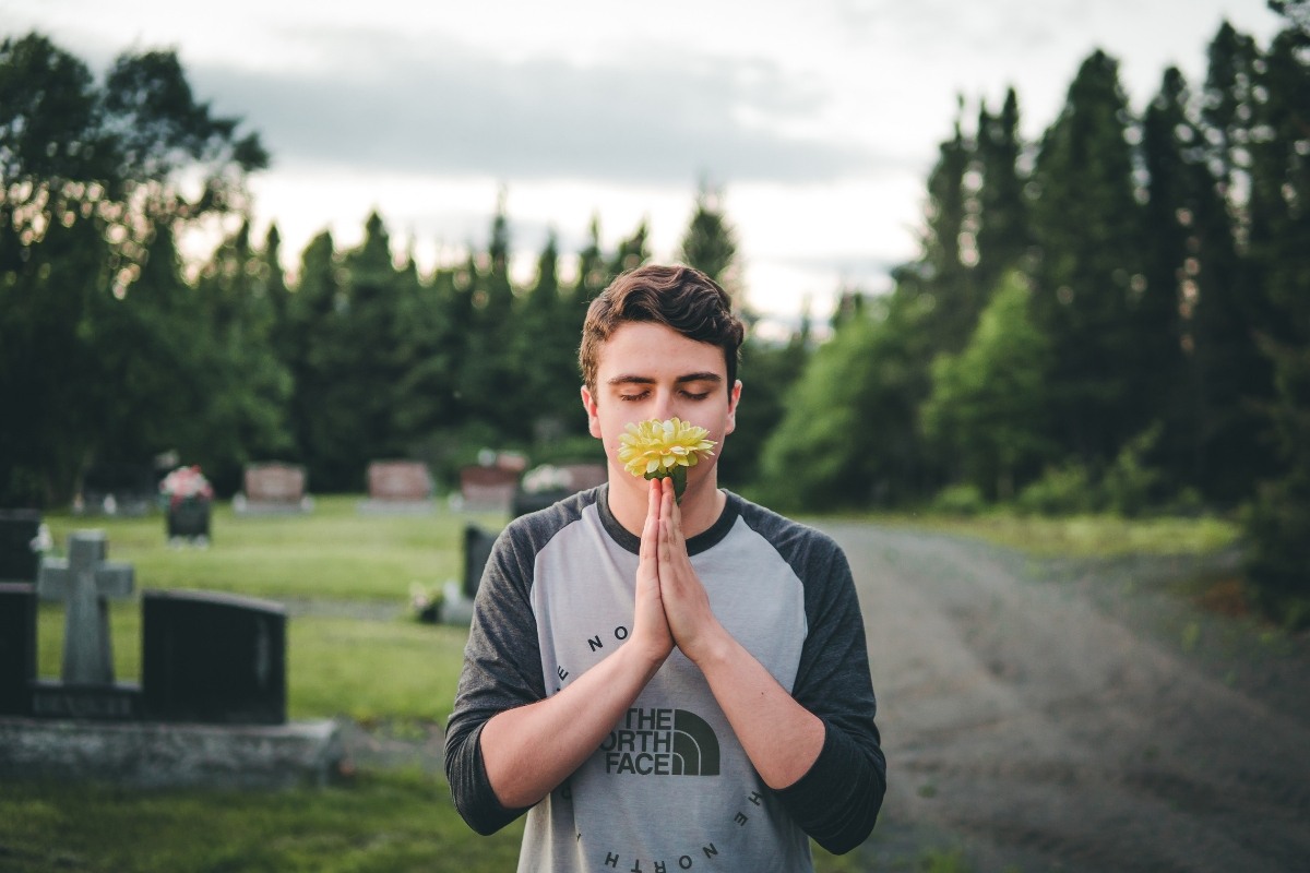 A man with healthy immune system smelling flowers