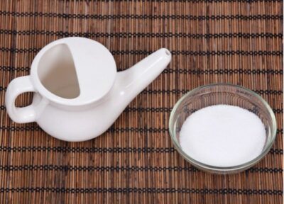 A neti pot with a bowl of salt