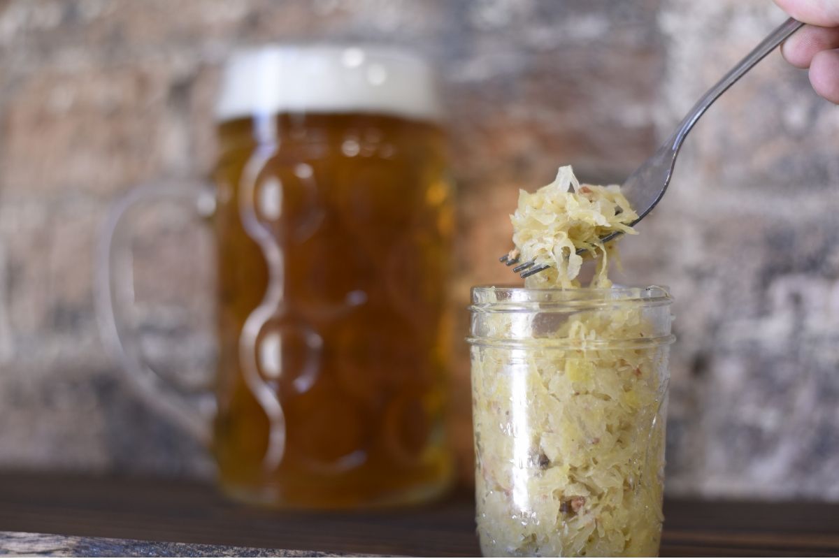 Sscooping sauerkraut out of a jar that contains probiotics