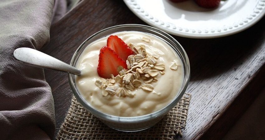 Plain yogurt topped with oats and strawberry contains probiotics