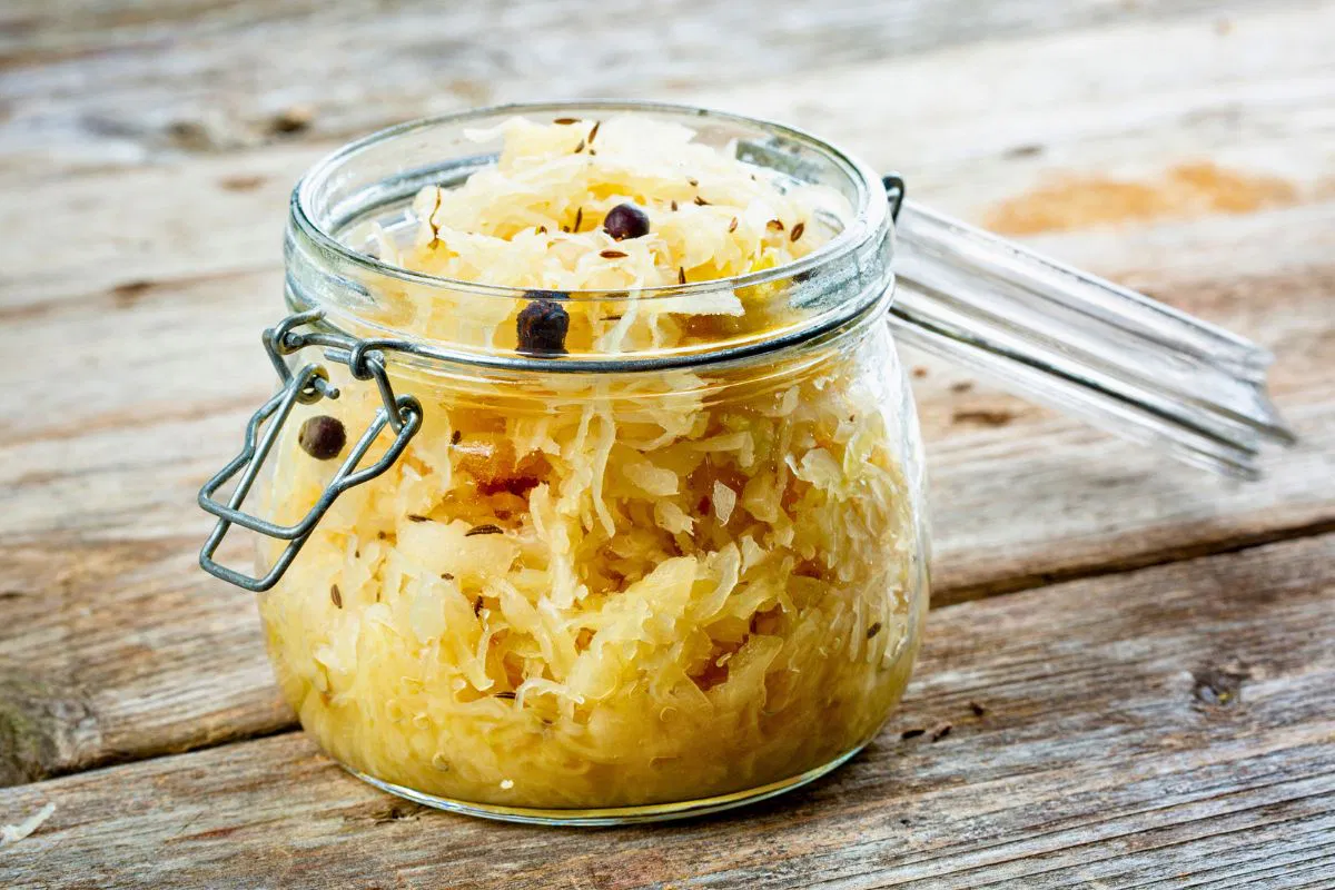 Mason jar filled with sauerkraut showcasing health benefits sauerkraut gives for gut health