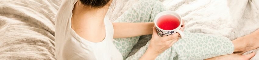 A woman drinking home-brewed kombucha before going to bed.