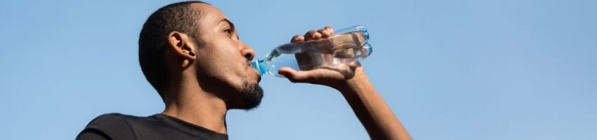 A man drinking water to ease constipation