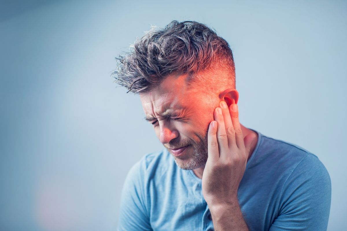 A man having ear pain because of glue ear