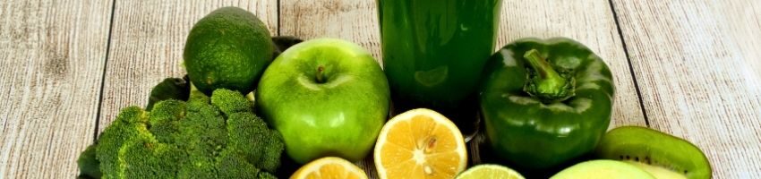 Glass of super healthy and delicious green juice with all the ingredients on the background