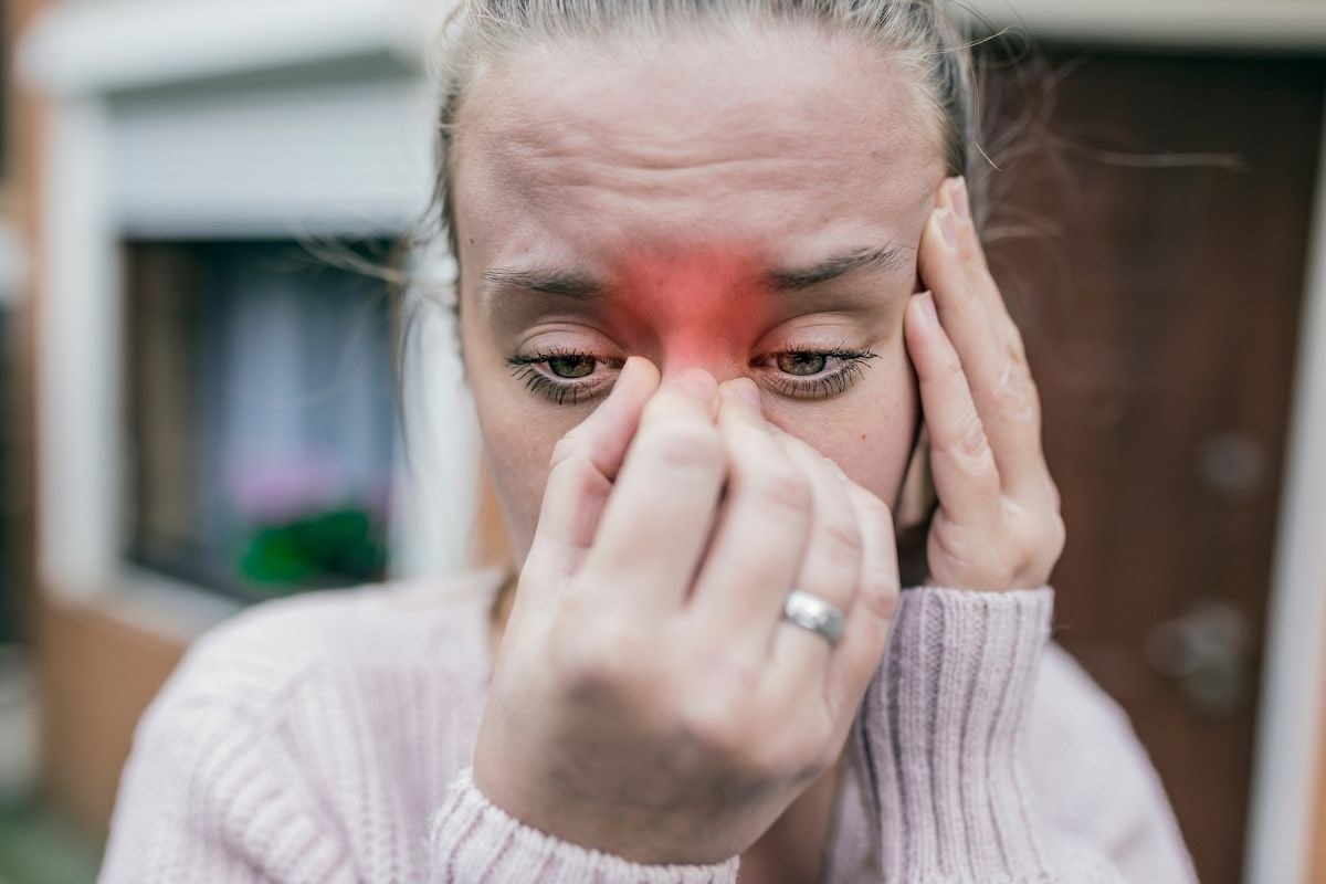 A woman trying to find her pressure points for sinus.