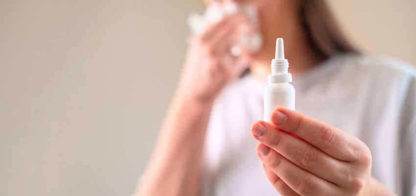 Woman applying saline rinse to relieve congestion and discomfort from sphenoid sinus infection.