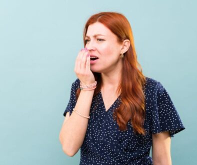 The woman smells if her breath still stinks.