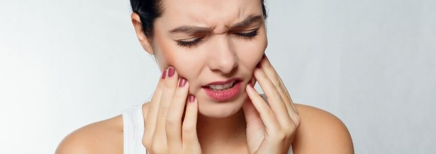 A woman wondering whether she's suffering from tooth pain or sinus pain.