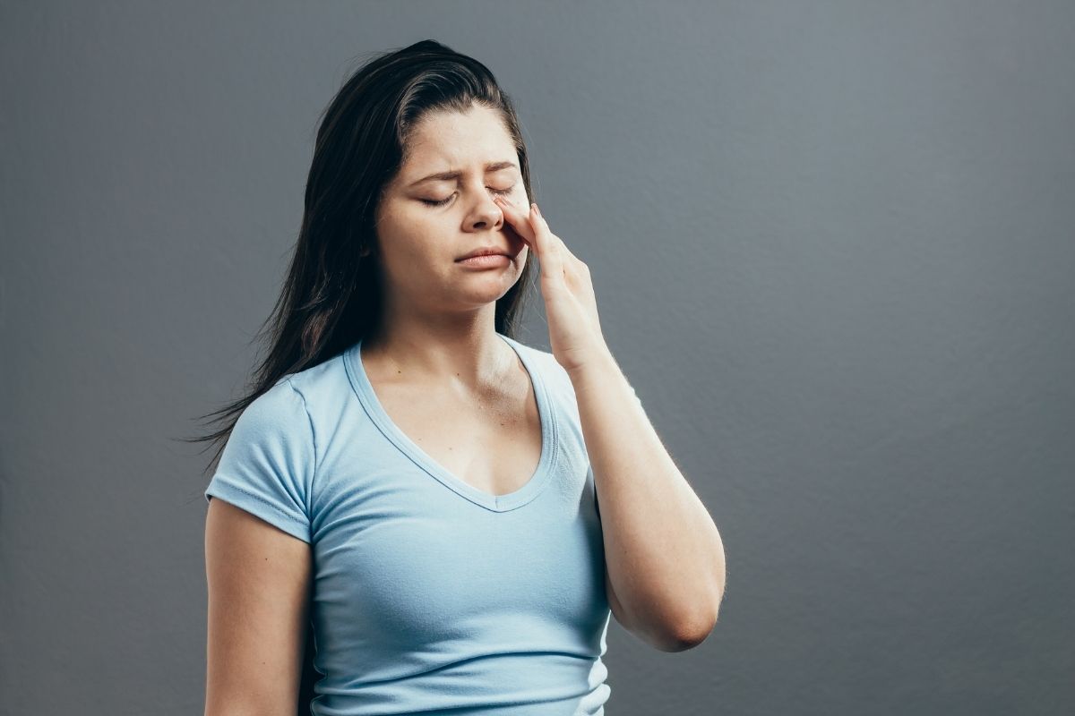 A woman wondering about the difference between tooth pain and sinus pain.