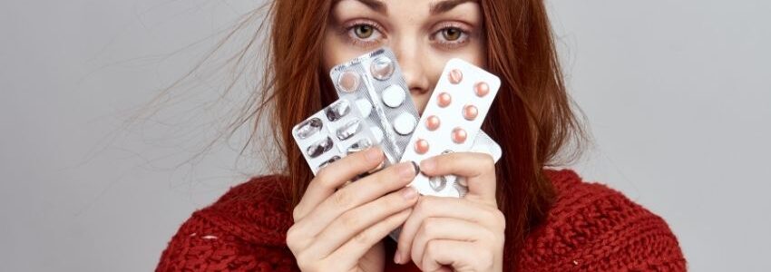 A woman showing the medications she's taking for allergies and sinus infection.