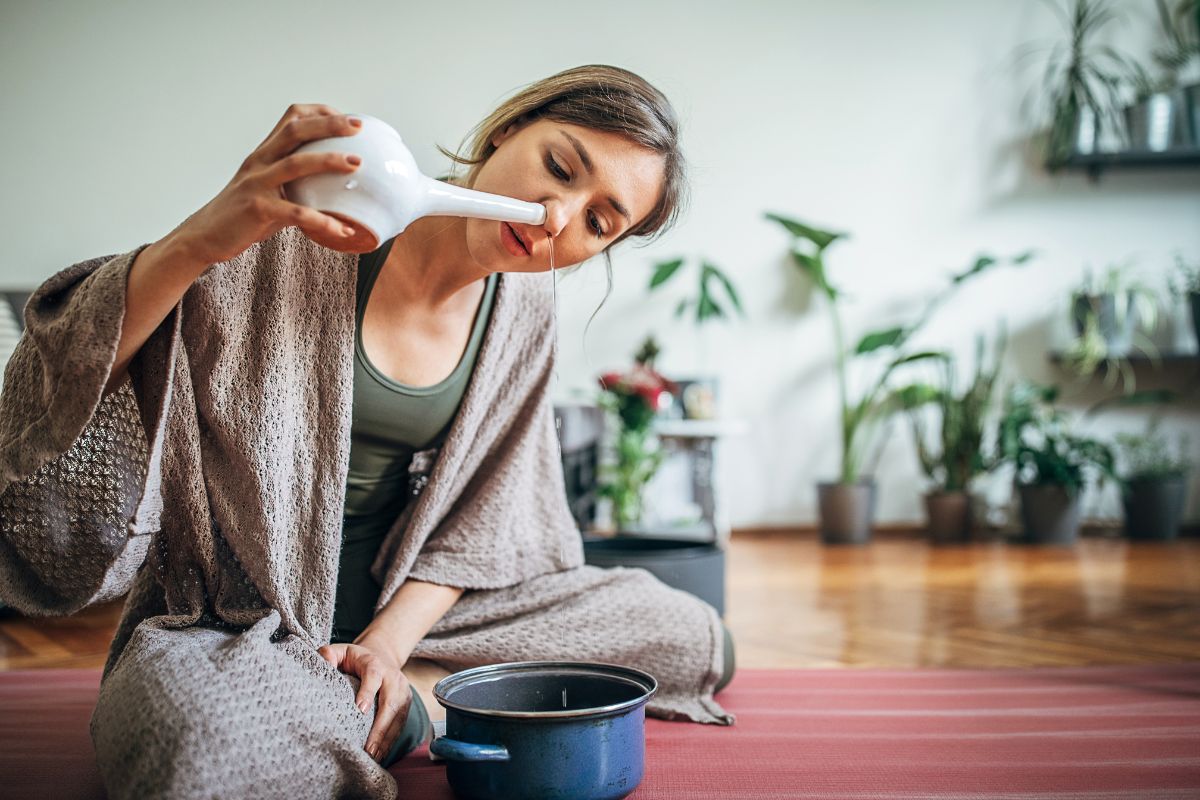 A woman using neti pot for sinusitis.