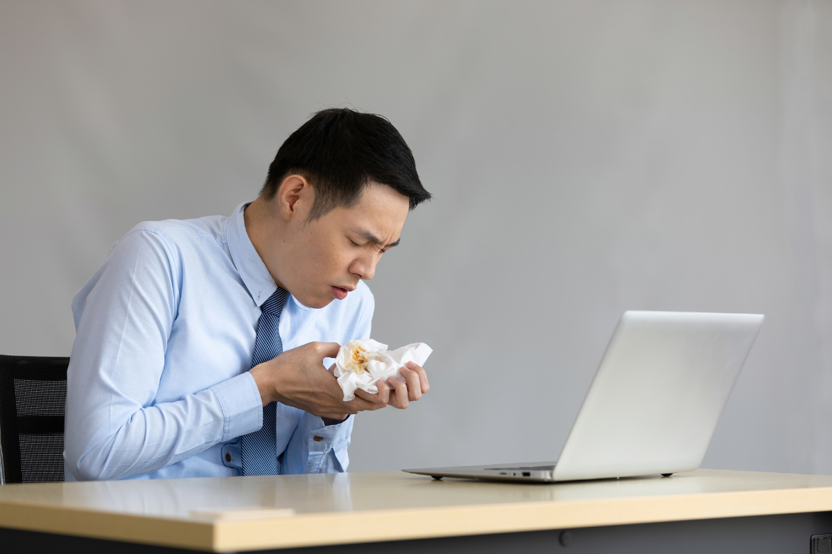 A man coughing while working.