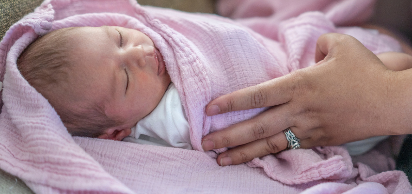 A baby wrapped in a swaddle.