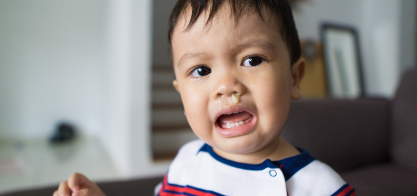 A crying baby with snot running down his nose.