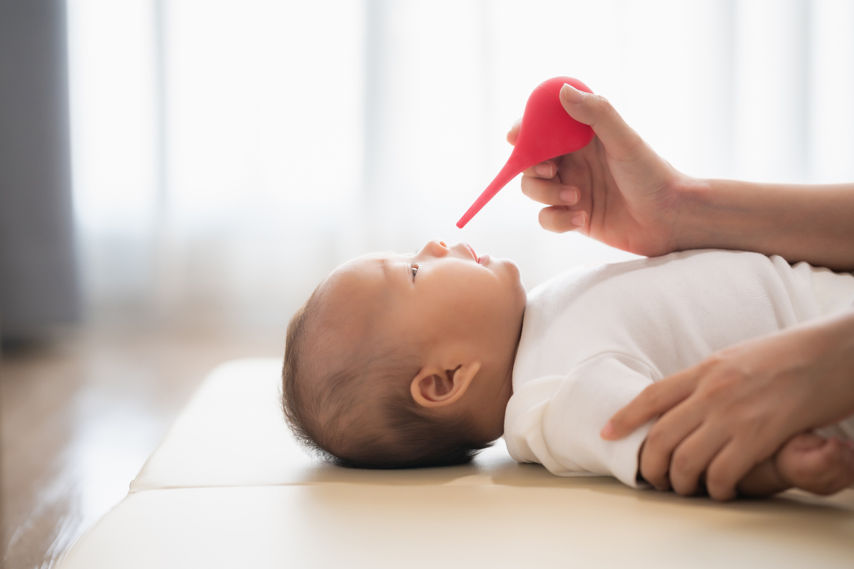 A baby getting treated with a neti pot.