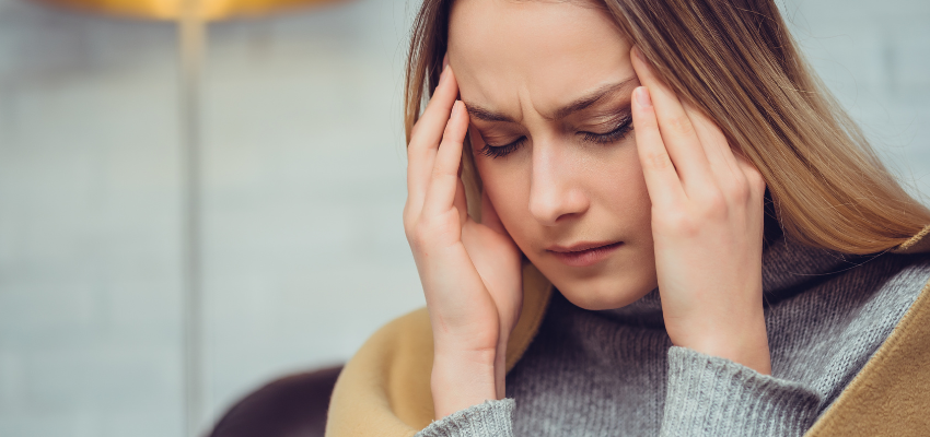 A woman has a migraine due to headaches and earaches.