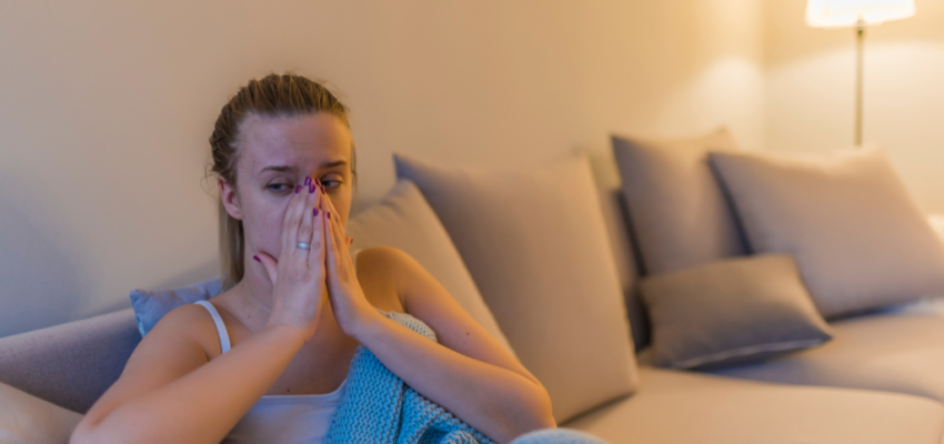 A woman massages her sinuses to drain the maxillary sinus.