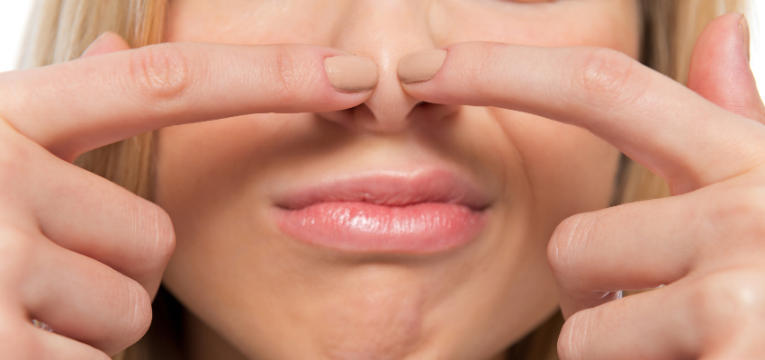 A woman is using the Toynbee Maneuver technique to pop her ears.