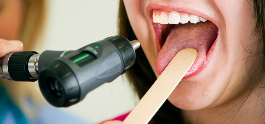 A woman goes to the doctor to check if she has a healthy tongue.