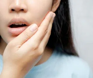 The woman feels discomfort due to oral thrush.