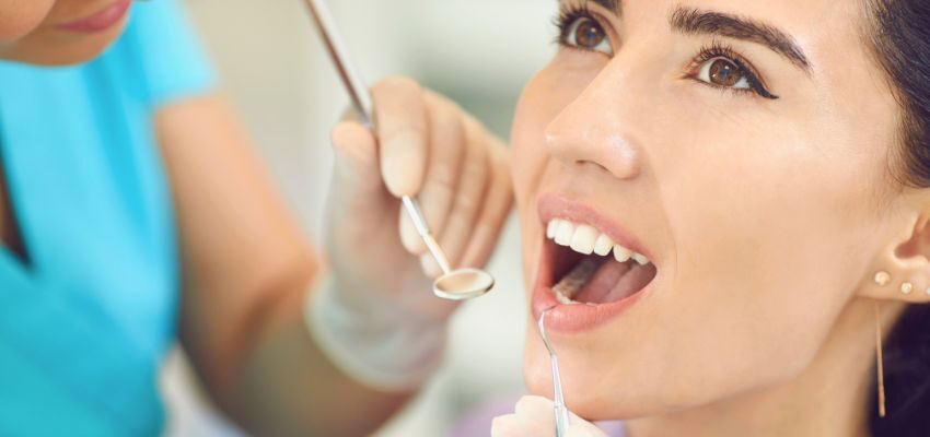 The dentist examines the woman's mouth to determine the cause of bad breath.