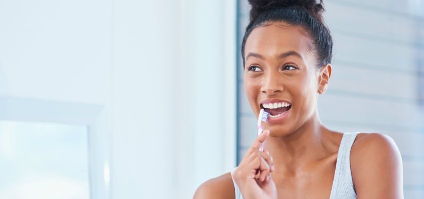The woman brushes her teeth regularly to prevent bad breath.