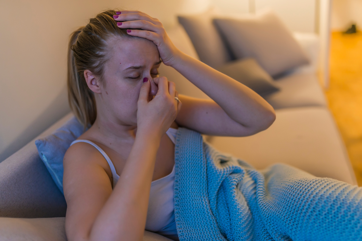 A woman is stressed, wondering why her sinus infection won't go away with antibiotics.