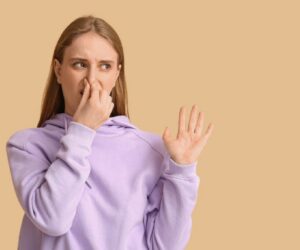 Woman reacting to unpleasant odor with tips on how to stop protein farts