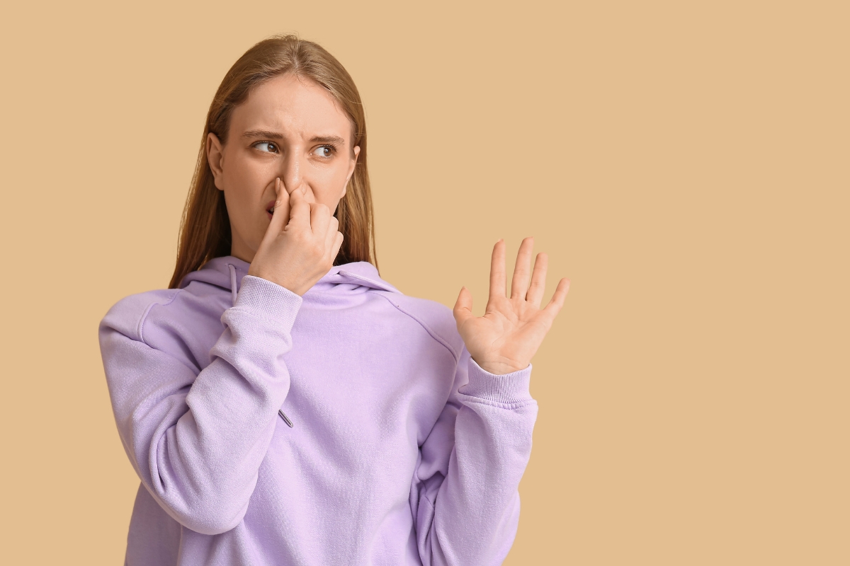 Woman reacting to unpleasant odor with tips on how to stop protein farts