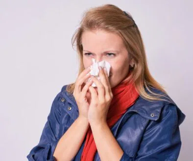 The woman is experiencing post-nasal drip.