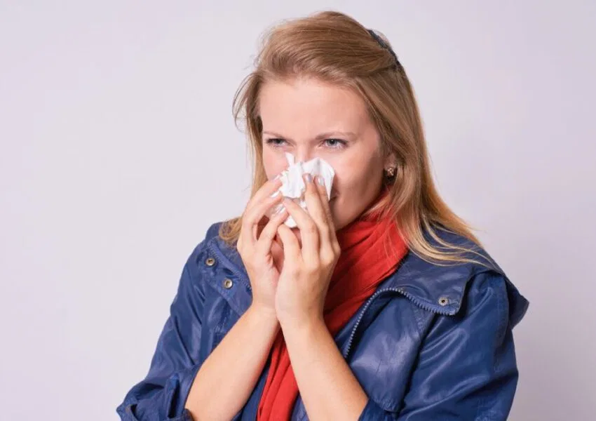 The woman is experiencing post-nasal drip.