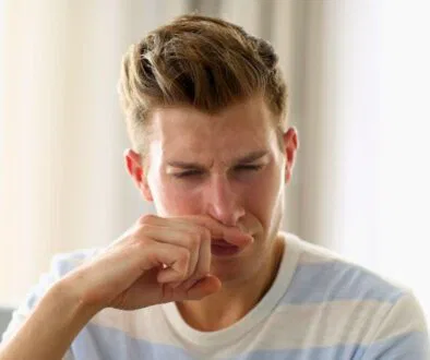 The man was disgusted by the bad smell in his nose.