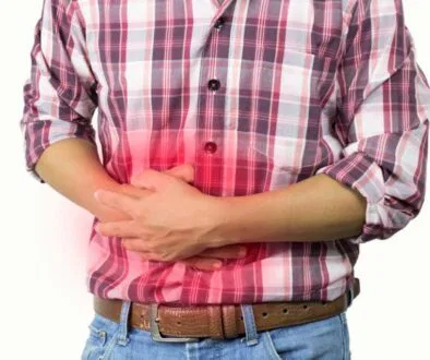 Man holding his stomach with red pain highlight, showing discomfort from constipation after antibiotics.