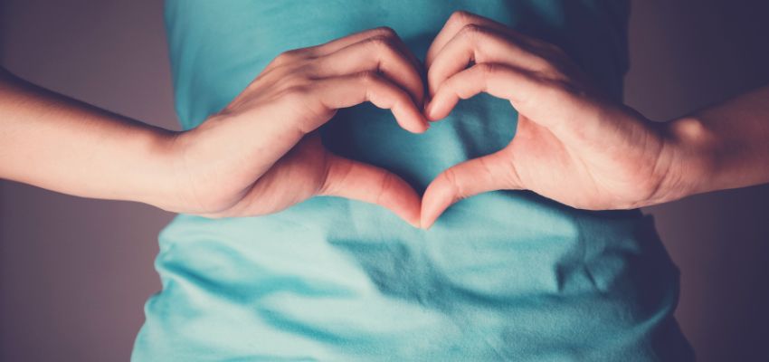 A person making a heart over their stomach after taking probiotics.