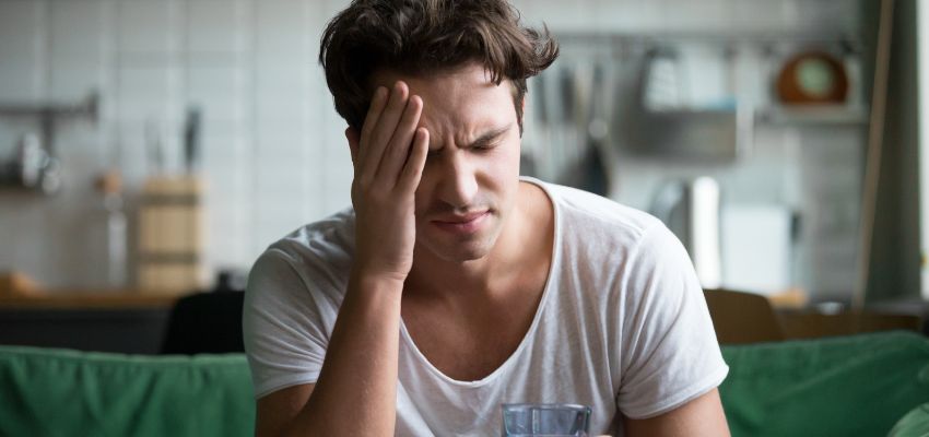 A person with a headache due to poor probiotic cultures in the stomach.