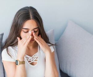 A woman is struggling with a sinus infection.