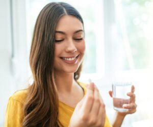 A woman is taking probiotics on an empty stomach.