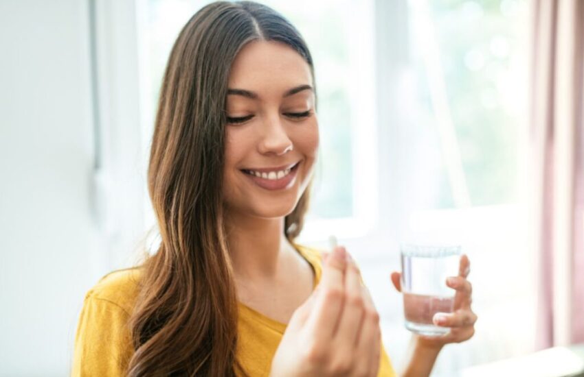 A woman is taking probiotics on an empty stomach.