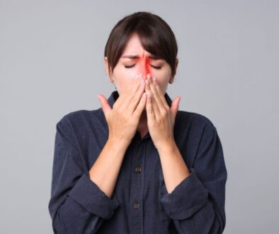 The woman is experiencing sinus pain.