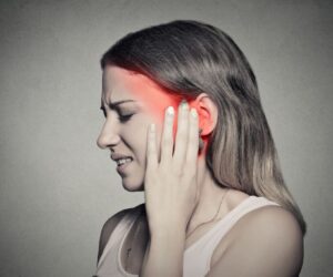 The woman feels pain due to ear congestion.