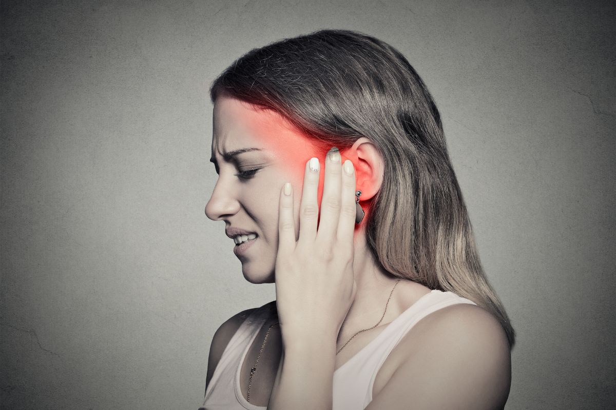 The woman feels pain due to ear congestion.