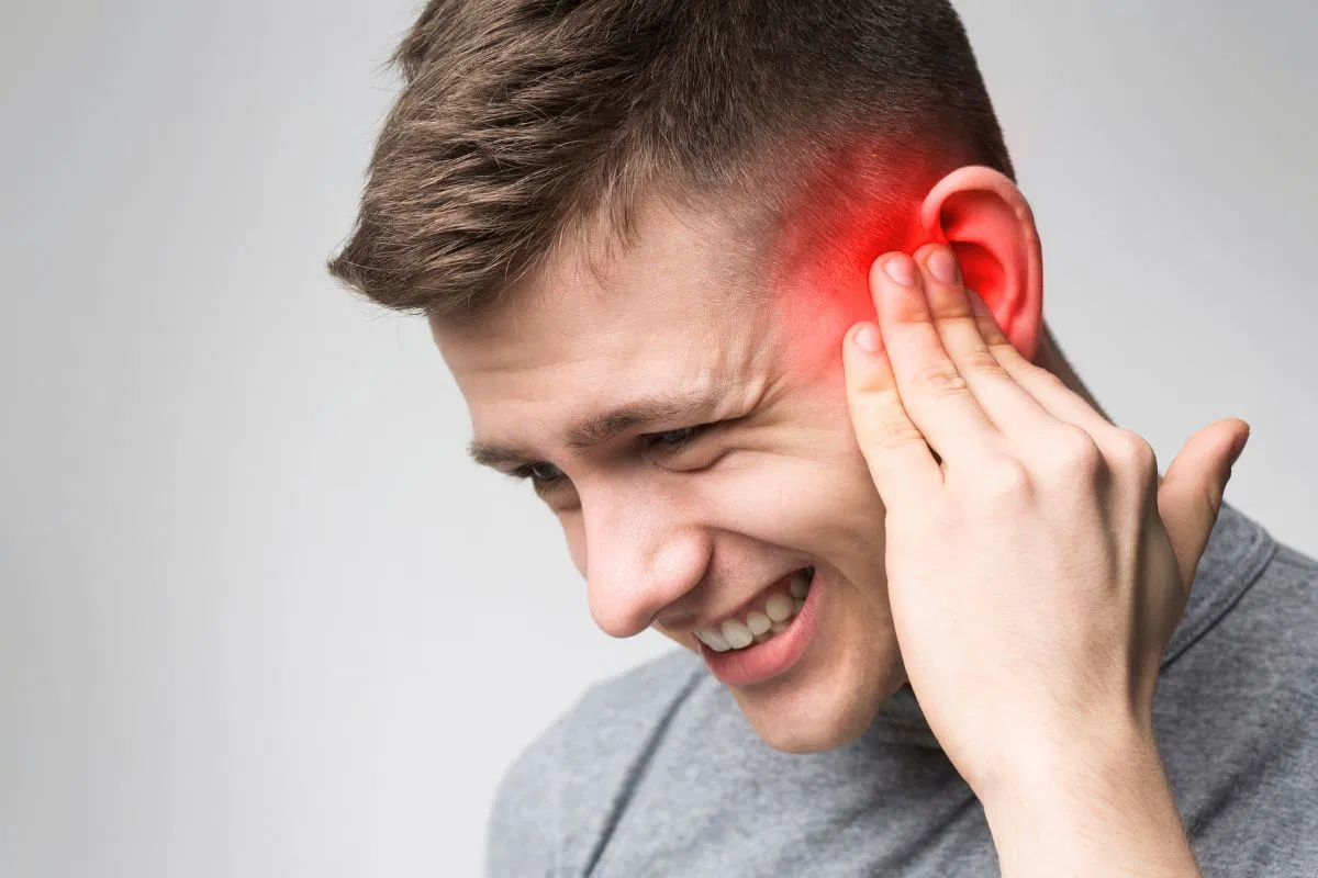 The man feels discomfort due to ear congestion.