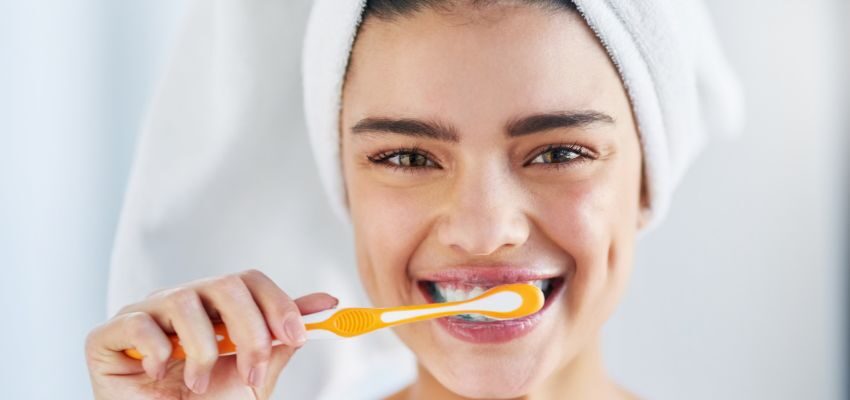 The woman is brushing her teeth.