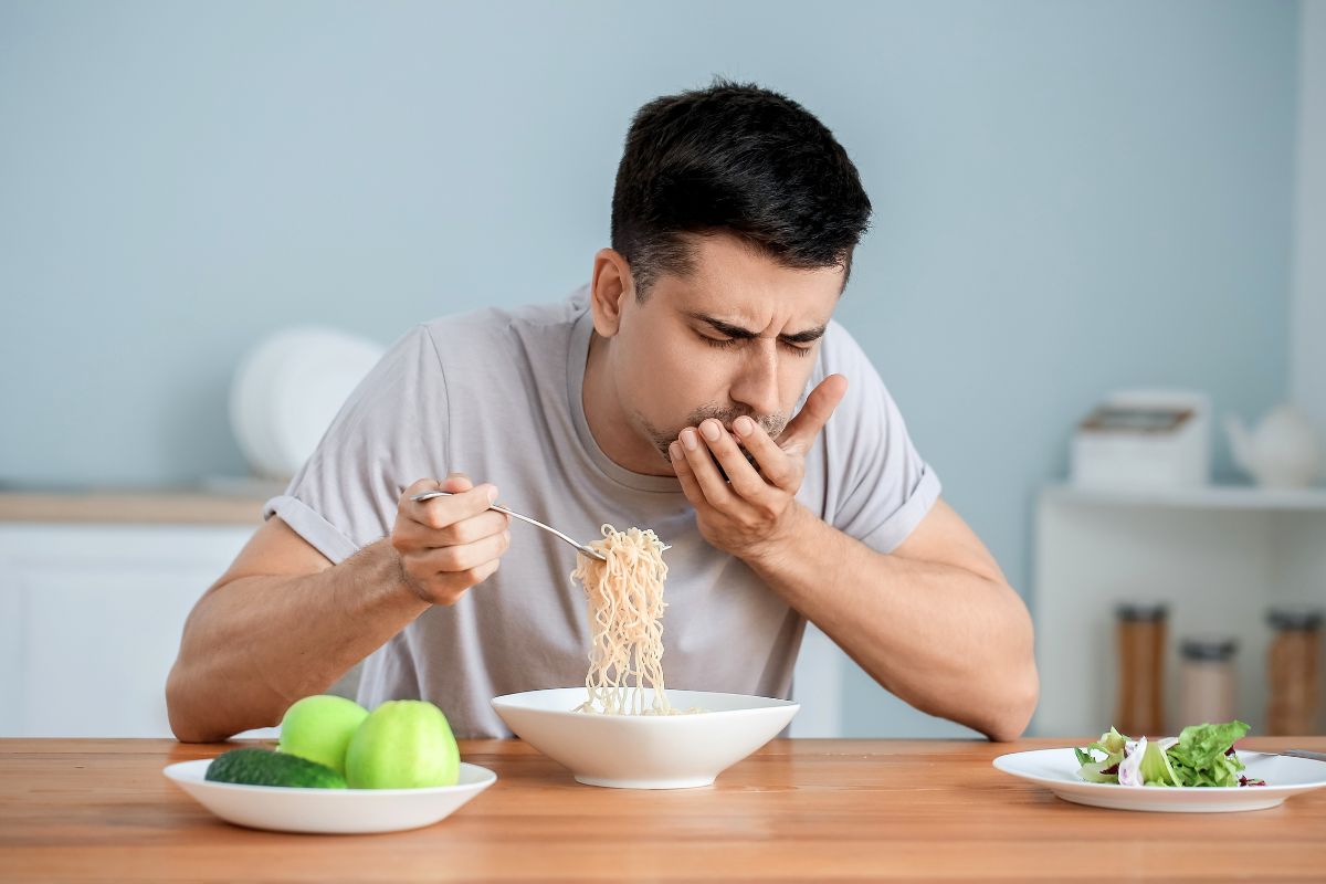 Man making a disgusted face while eating because everything tastes salty