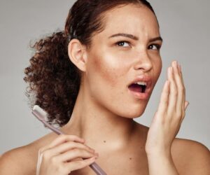 The woman checks if she still has smoke breath.
